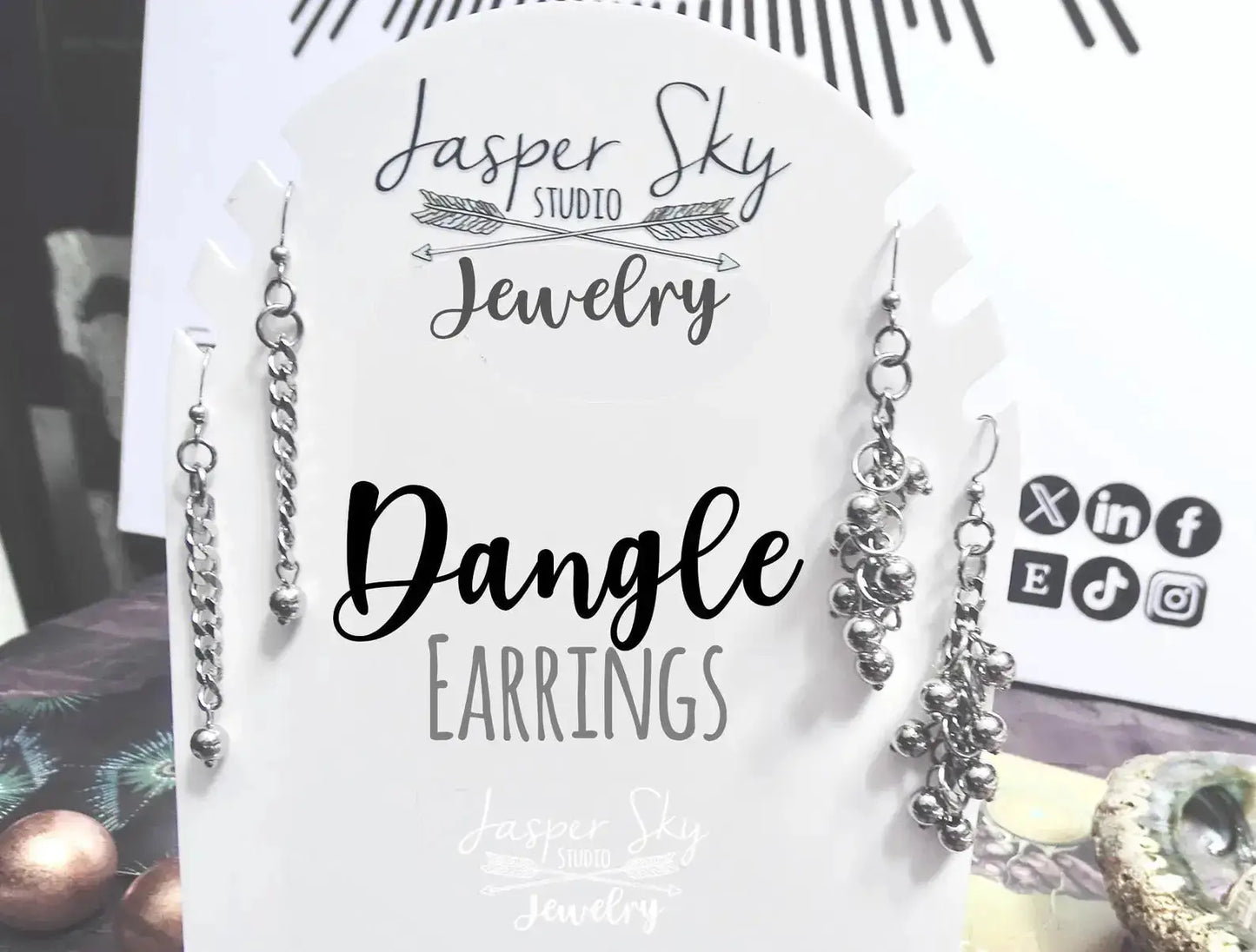 Various handcrafted silver dangle earrings on branded display card. Stylish and versatile jewelry gift for women.