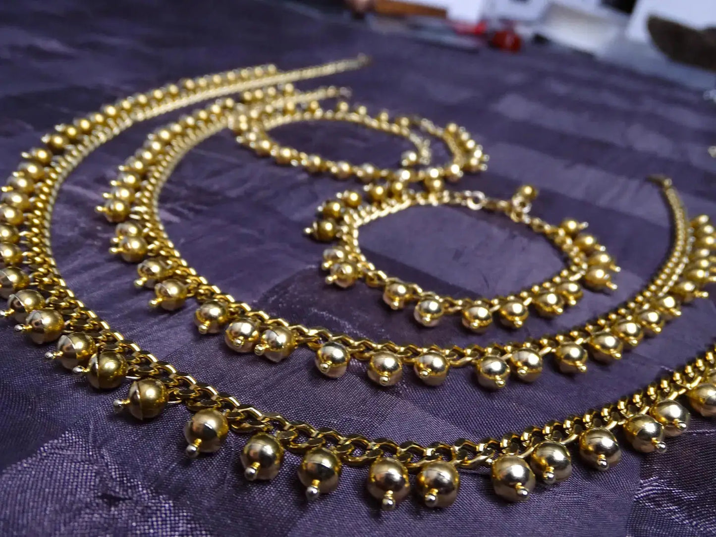 Close-up of matching gold jewelry set with beaded chain design, complementing the Handcrafted Gold Long Dangle Earrings collection.