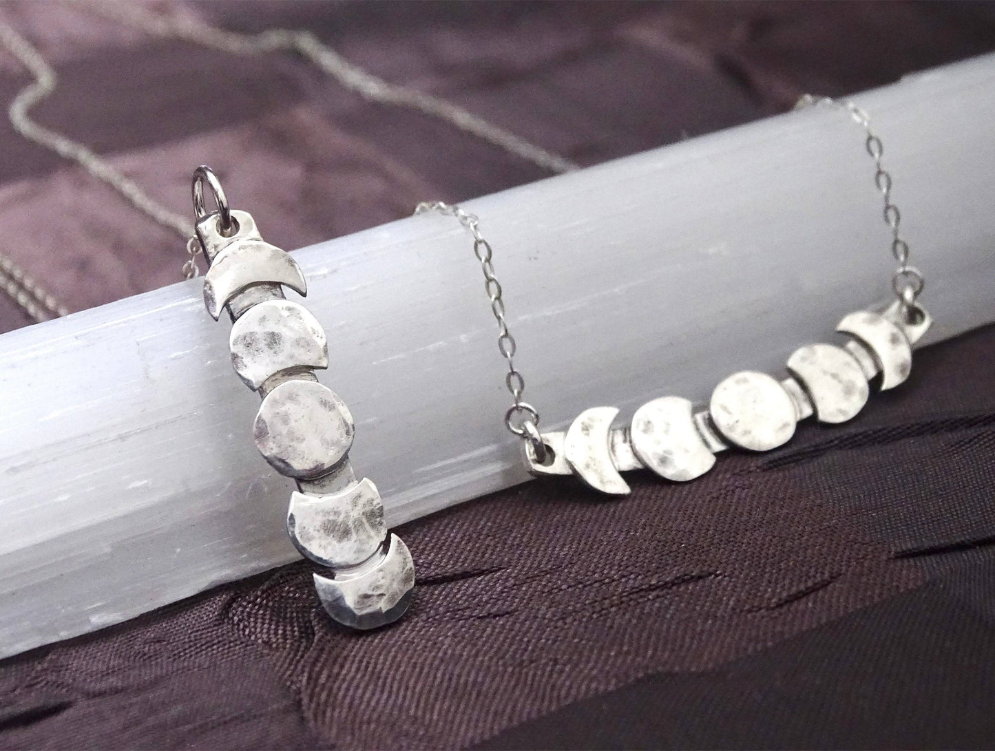 Detailed view of vertical and horizontal moon phase pendants in hammered sterling silver, ideal for celestial jewelry lovers.