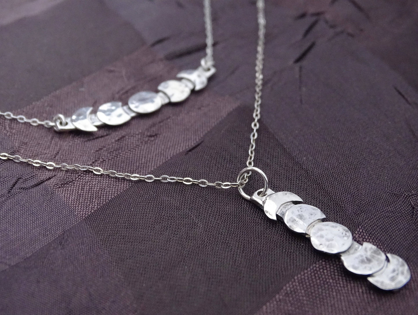 Sterling silver moon phase necklaces with hammered finish, featuring celestial lunar cycle in vertical and horizontal styles.