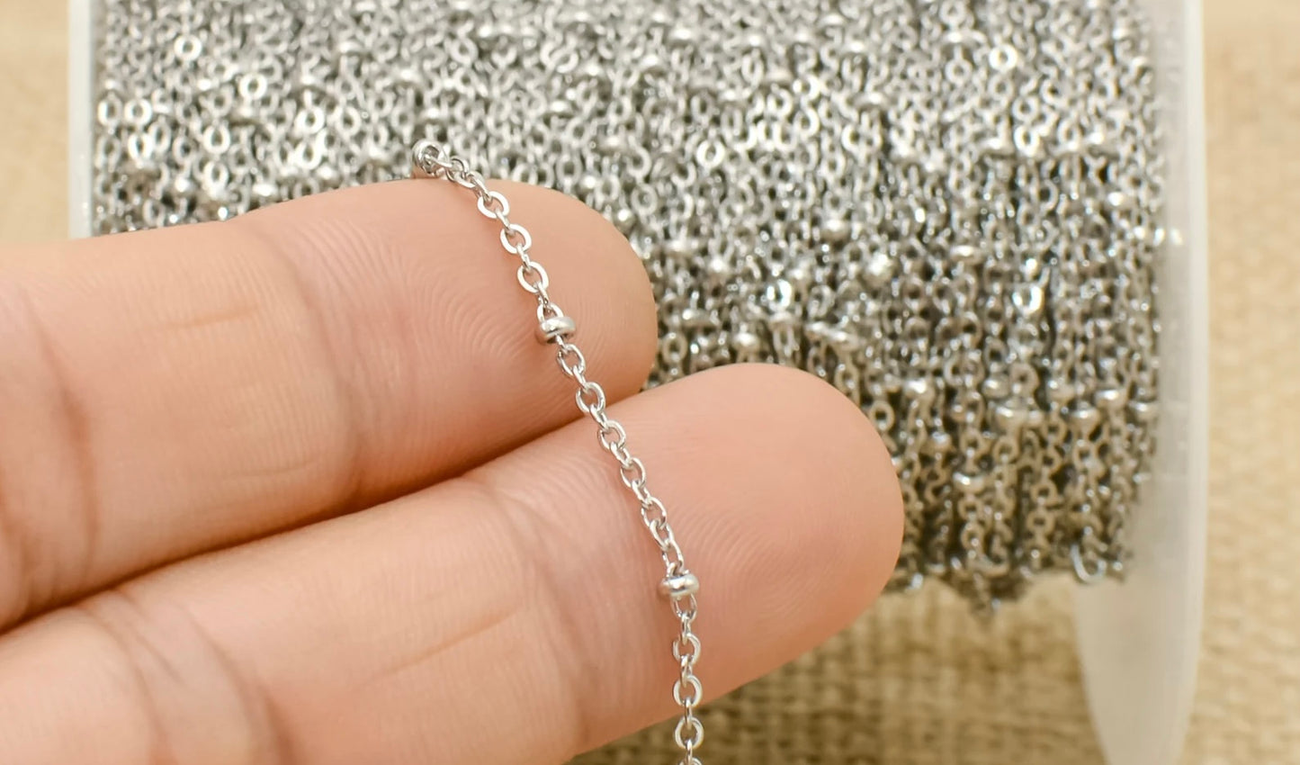 Close-up of sterling silver chain roll with delicate links, ideal for crafting or pairing with handmade mushroom pendants.