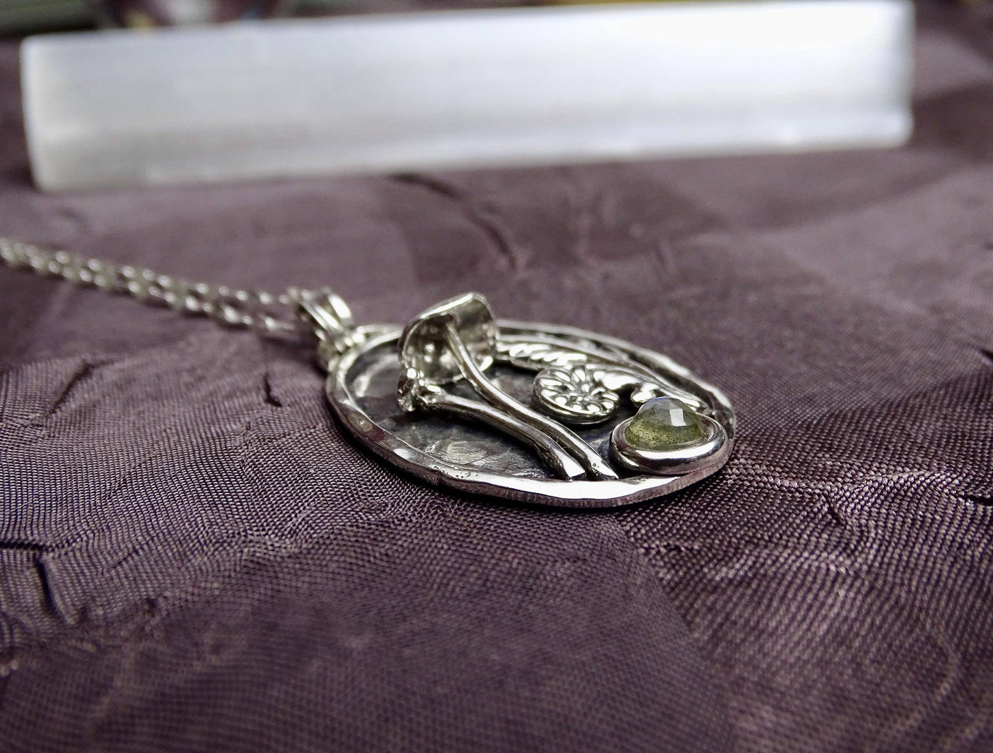 Side profile of sterling silver pendant with mushroom, fern, and labradorite, highlighting its raised relief and artisan craftsmanship.